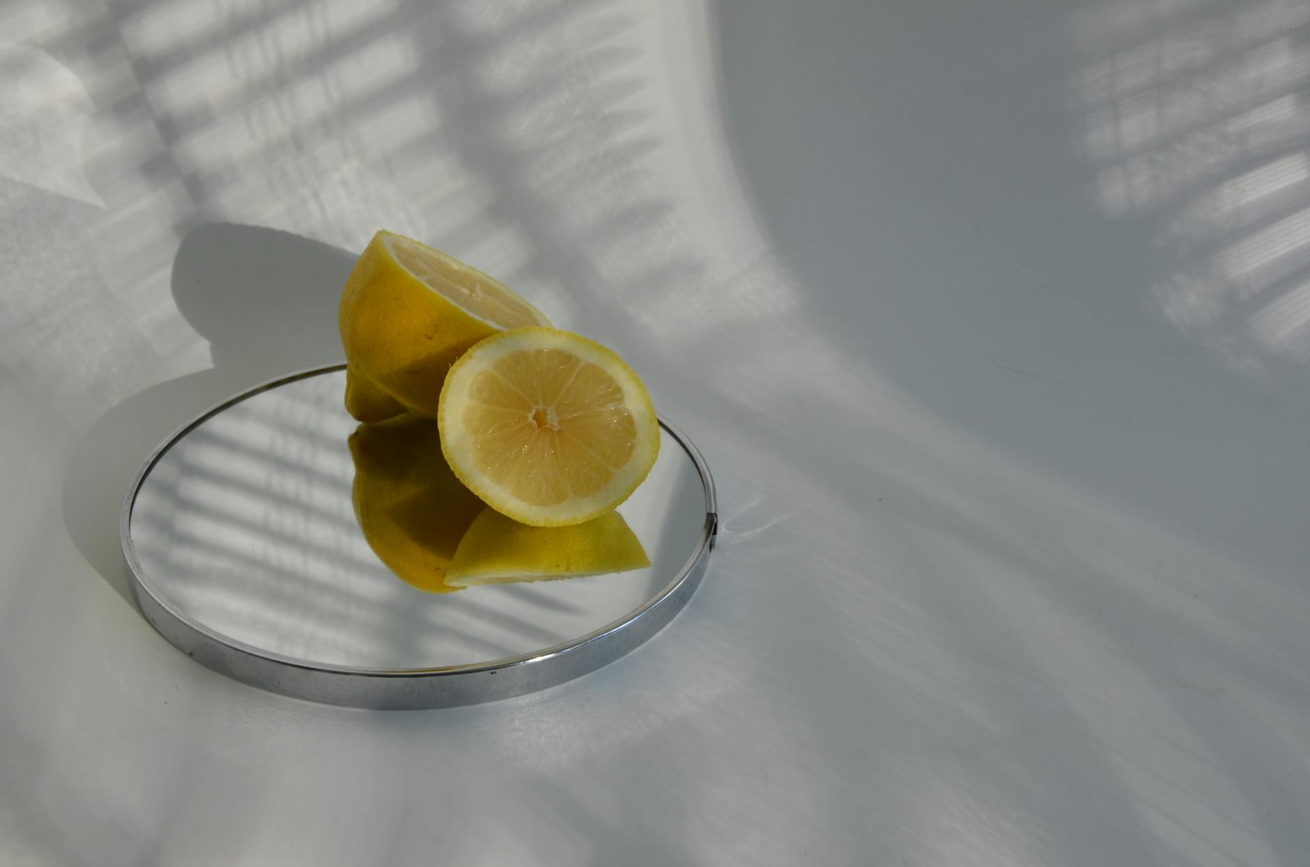 Two women laughing together while enjoying time with sliced lemons and plants indoors