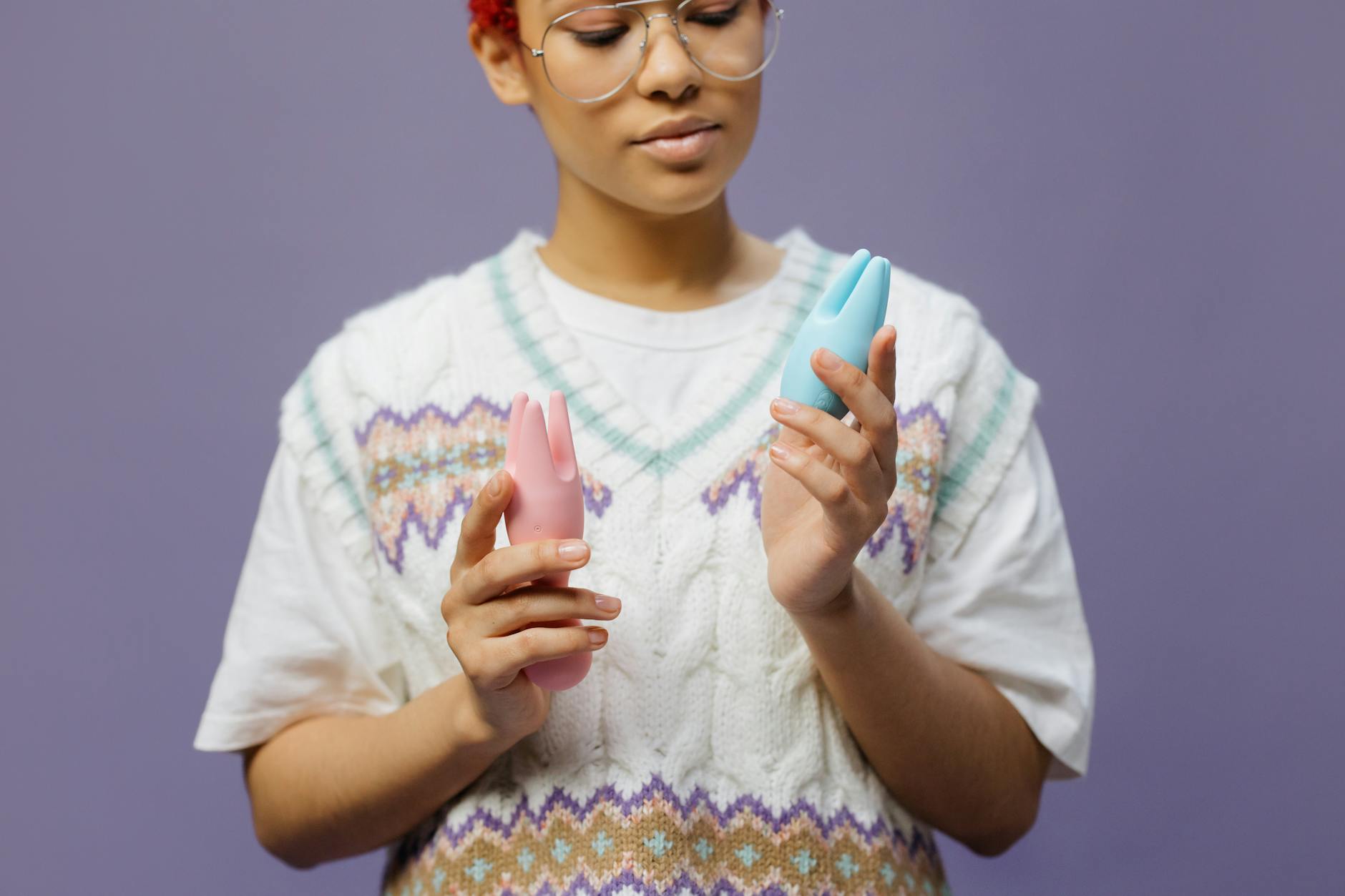 Woman holding colorful clitoral vibrators, exploring pleasure tools for reduced sensation