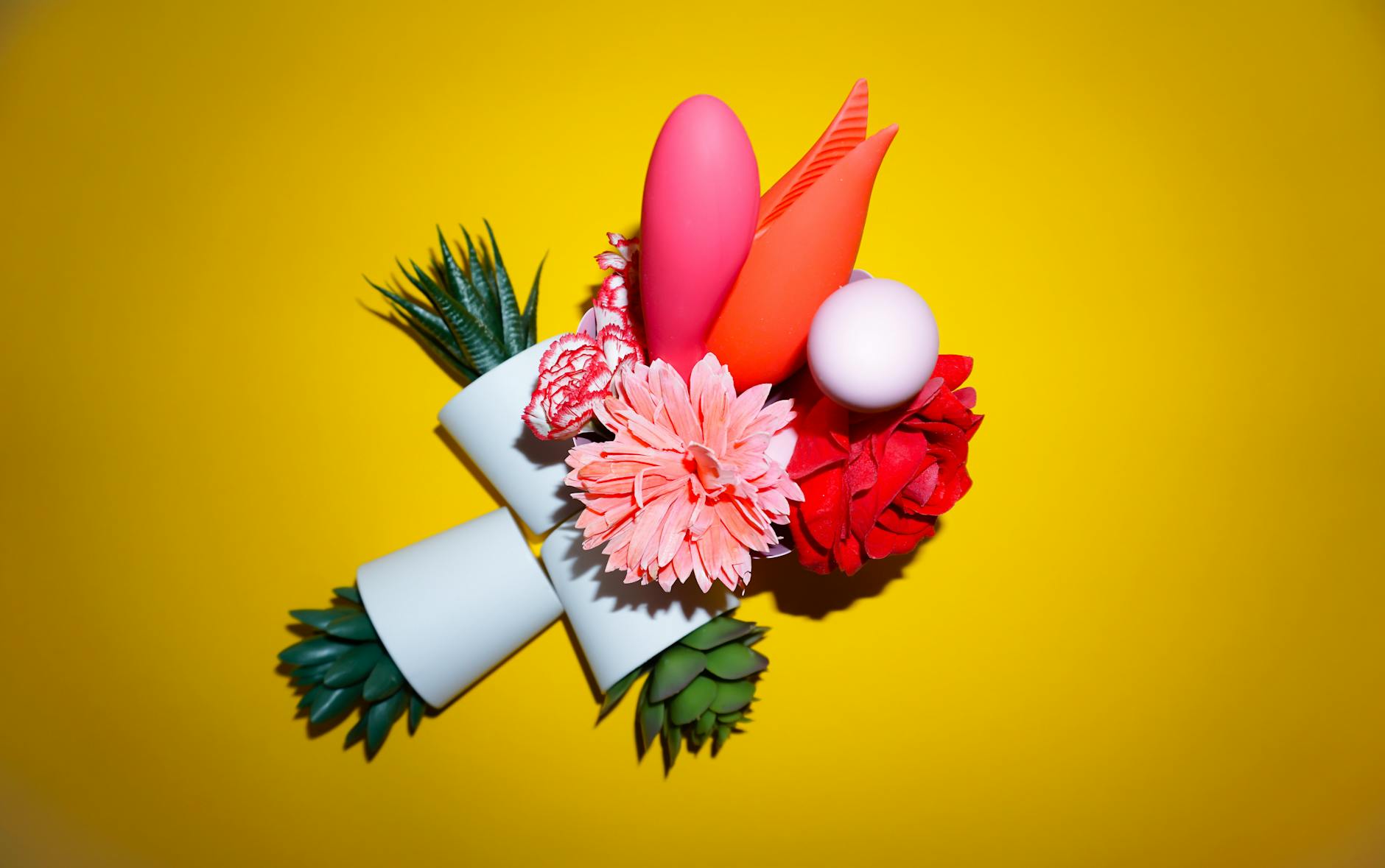A yellow silicone lemon vibrator surrounded by peeled bananas on a bright yellow background